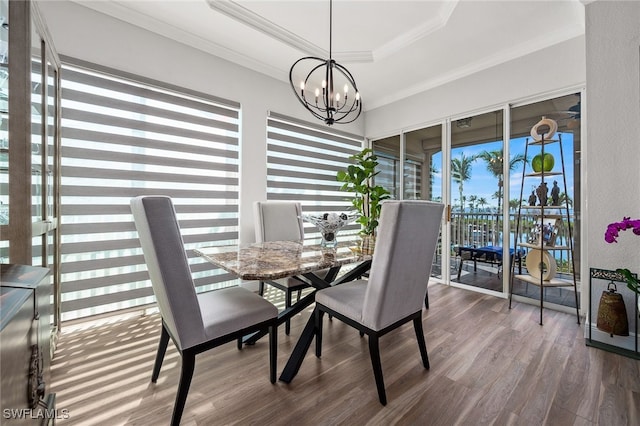 14328 Harbour Landings Dr Unit 18C, Fort Myers, FL 33908 - dining room with a raised ceiling, dark wood-type flooring, a chandelier, and ornamental molding