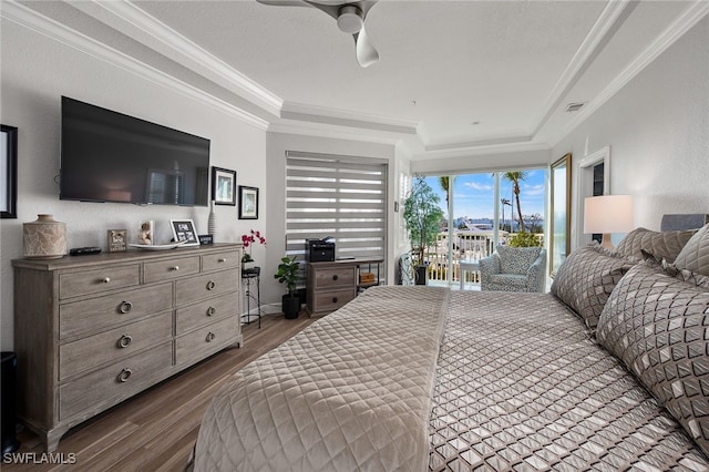 bedroom with a raised ceiling, dark wood finished floors, ceiling fan, ornamental molding, and access to outside