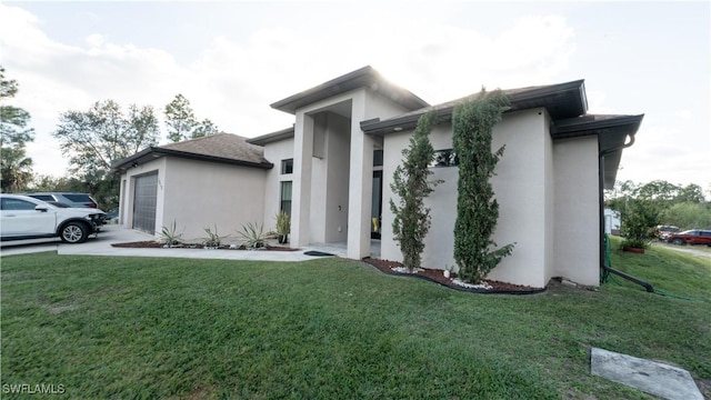 view of front of property featuring a front lawn, concrete driveway, an attached garage, and stucco siding