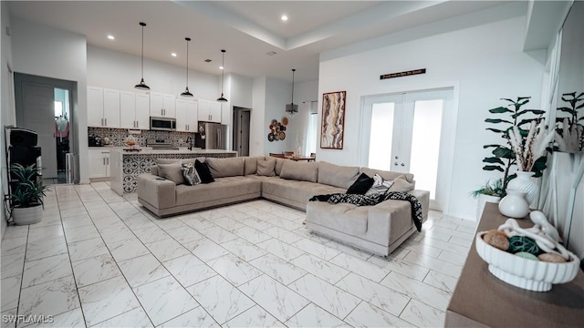 living room featuring recessed lighting, french doors, marble finish floor, and a high ceiling