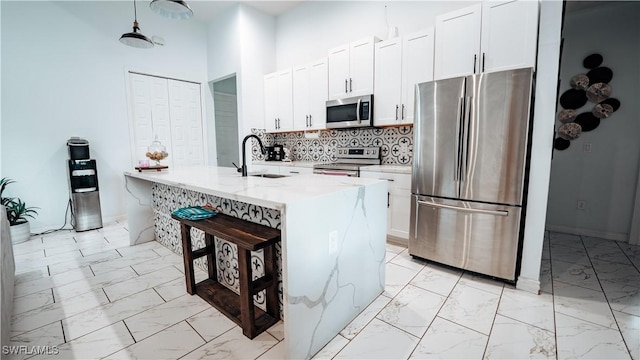 kitchen featuring appliances with stainless steel finishes, marble finish floor, white cabinetry, and a sink