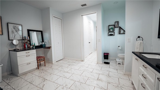 bathroom featuring toilet, vanity, visible vents, baseboards, and marble finish floor