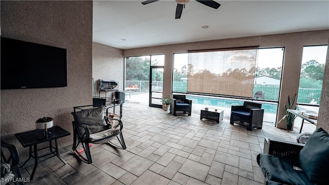 interior space featuring a ceiling fan and an outdoor pool