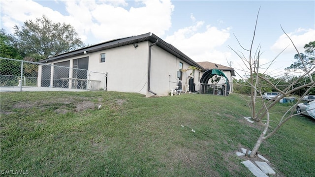 view of side of home with a yard, fence, and stucco siding