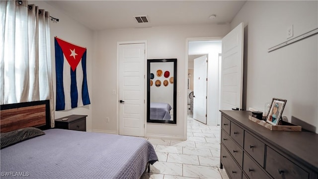 bedroom with marble finish floor, visible vents, and baseboards