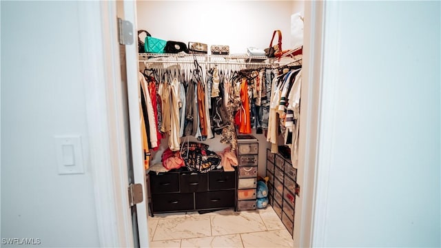 spacious closet featuring marble finish floor