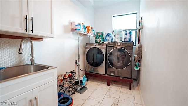 washroom with marble finish floor, washing machine and dryer, a sink, and cabinet space