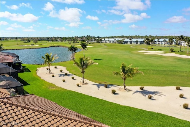 view of community featuring a yard, golf course view, and a water view