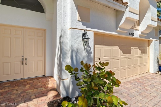 property entrance featuring driveway and stucco siding