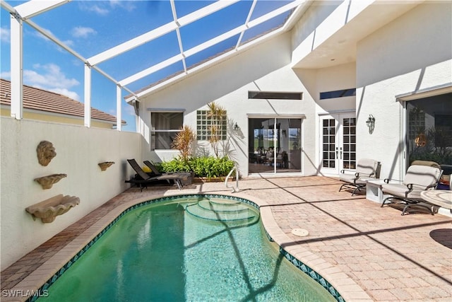 pool with french doors, a patio area, and a lanai