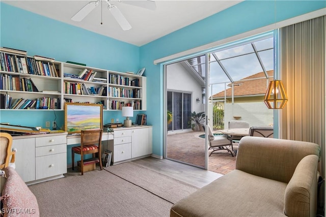 living area with lofted ceiling, light carpet, and ceiling fan