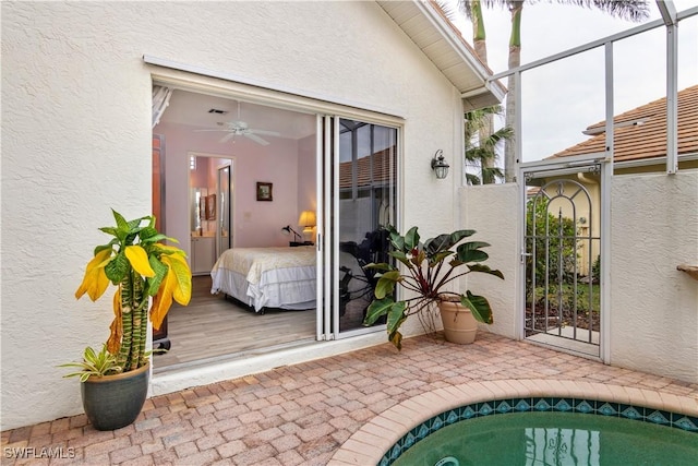 view of exterior entry featuring an outdoor pool, a patio, and stucco siding