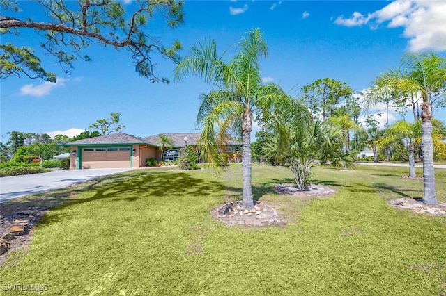 view of front of house with a garage, a front yard, and driveway