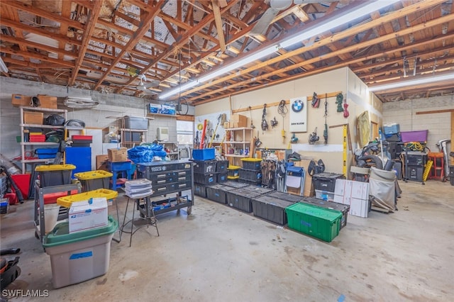 garage with concrete block wall and a workshop area