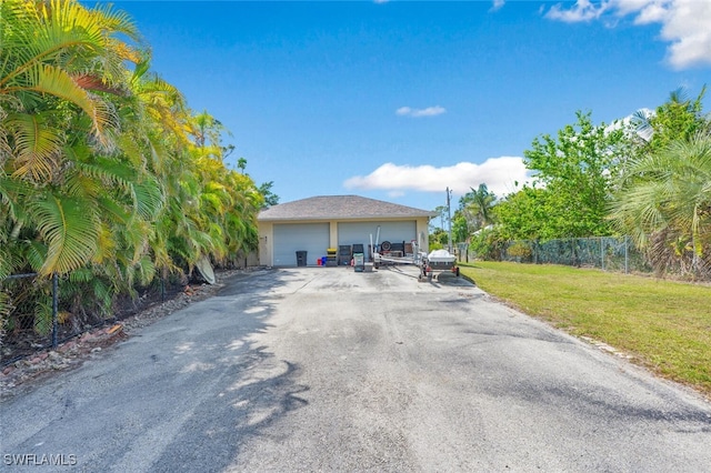 view of front of home featuring a garage, a front lawn, and fence