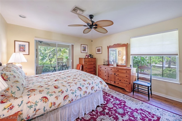 bedroom featuring visible vents, a ceiling fan, wood finished floors, access to outside, and baseboards