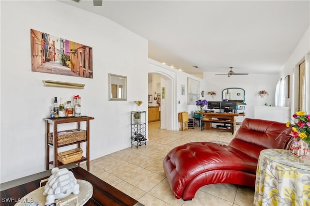 tiled living room featuring ceiling fan and arched walkways