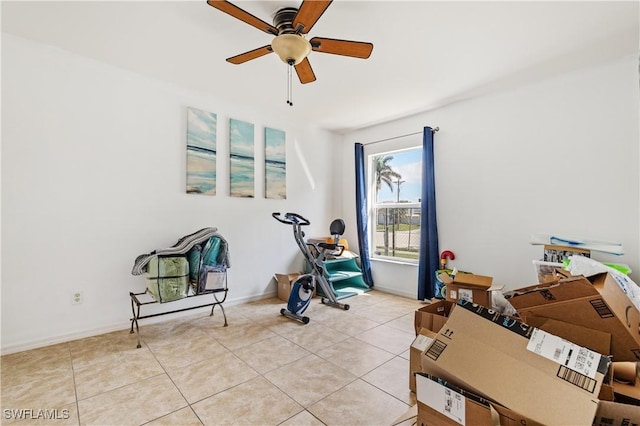 exercise room with light tile patterned floors, baseboards, and a ceiling fan