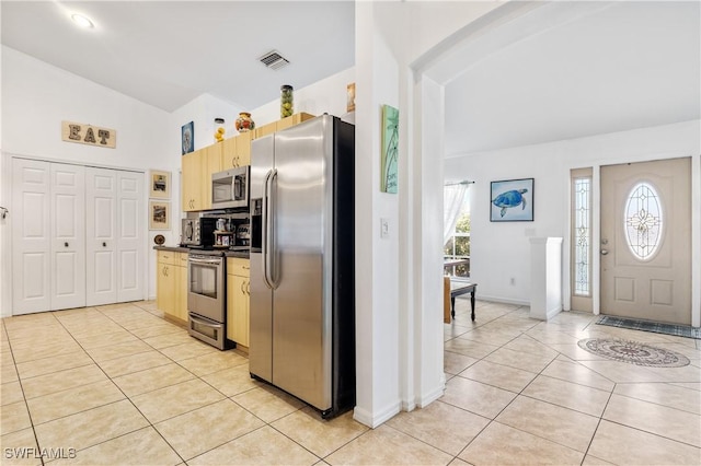 kitchen featuring dark countertops, light tile patterned floors, visible vents, and stainless steel appliances