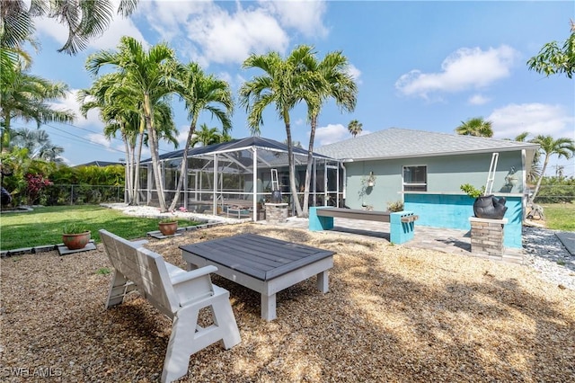 rear view of property featuring a lanai, a yard, an outdoor pool, and stucco siding