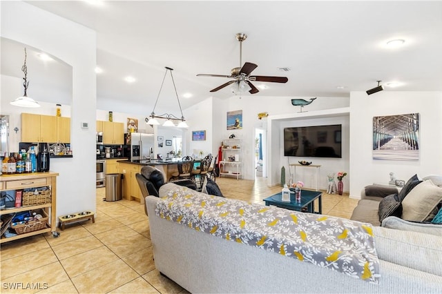 living room featuring lofted ceiling, visible vents, a ceiling fan, and light tile patterned flooring