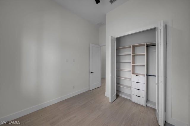 unfurnished bedroom with light wood-style floors, baseboards, and a closet