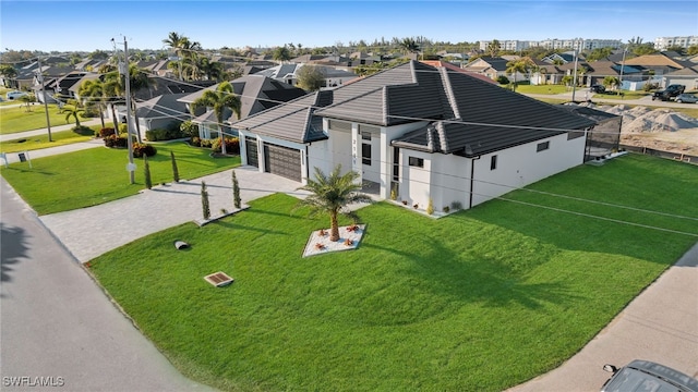 view of front of house featuring driveway, a front lawn, a tiled roof, and a residential view