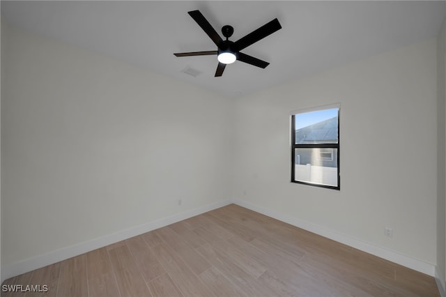 spare room with light wood finished floors, baseboards, visible vents, and ceiling fan