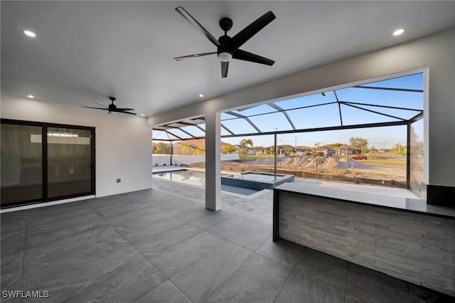 view of patio / terrace with a pool with connected hot tub, glass enclosure, and ceiling fan