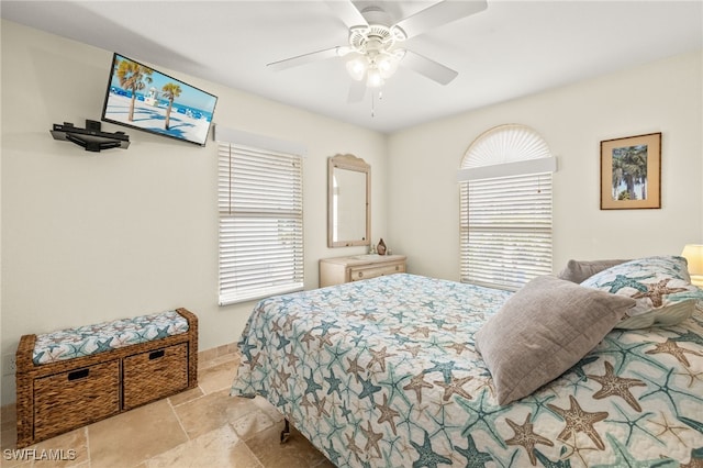 bedroom with stone finish flooring, baseboards, and ceiling fan