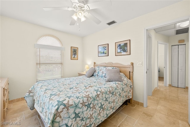 bedroom featuring stone tile floors, visible vents, a ceiling fan, and baseboards