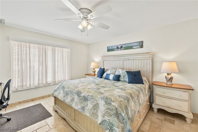 bedroom featuring visible vents, ceiling fan, and stone finish floor