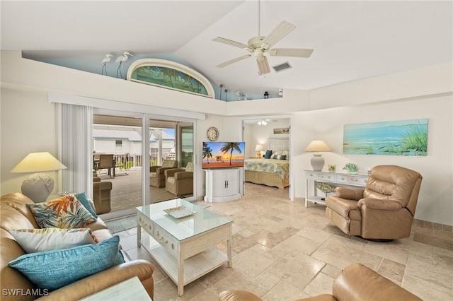 living area with visible vents, lofted ceiling, stone tile floors, and a ceiling fan