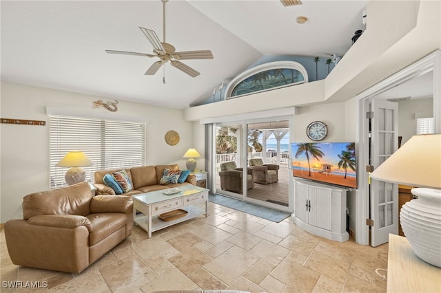 living room featuring stone tile floors, high vaulted ceiling, and ceiling fan