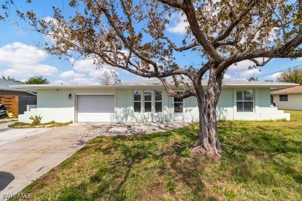 ranch-style house with a garage, driveway, a front yard, and stucco siding