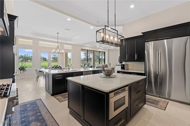 kitchen featuring stainless steel appliances, dark cabinetry, a kitchen island, and light countertops