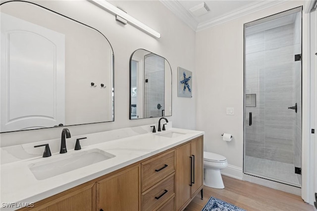 bathroom with toilet, crown molding, a sink, and a shower stall