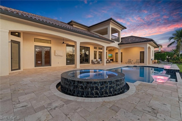 view of swimming pool featuring a ceiling fan, a pool with connected hot tub, french doors, and a patio