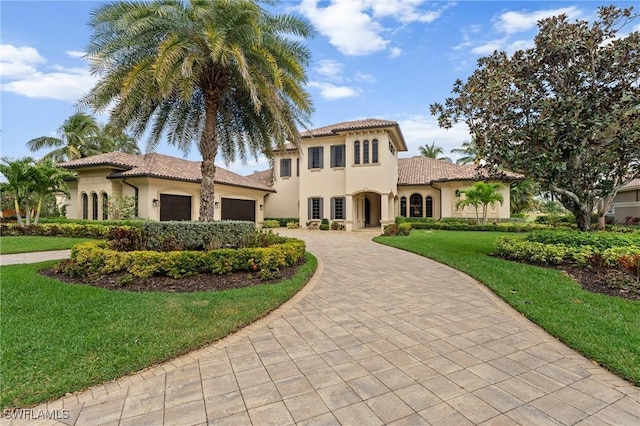 mediterranean / spanish-style home featuring a garage, a tiled roof, decorative driveway, and stucco siding