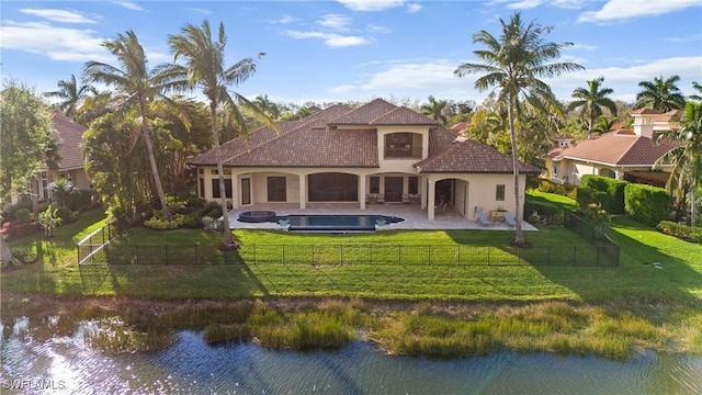 rear view of house with a patio, a fenced backyard, a water view, a lawn, and a fenced in pool