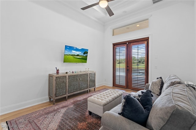 living area with french doors, crown molding, baseboards, and wood finished floors