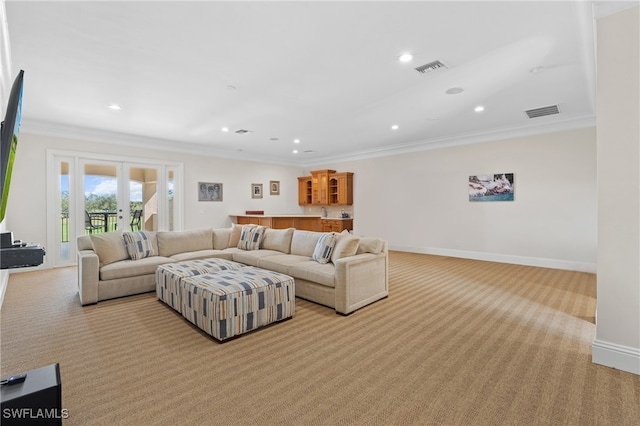 living area featuring french doors, light colored carpet, visible vents, ornamental molding, and baseboards