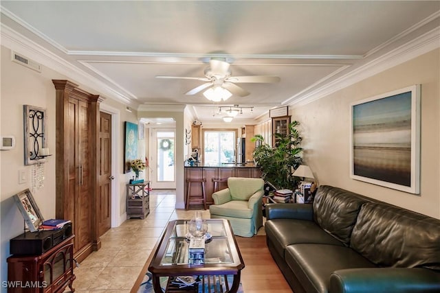 living area featuring ceiling fan, light tile patterned floors, visible vents, and crown molding