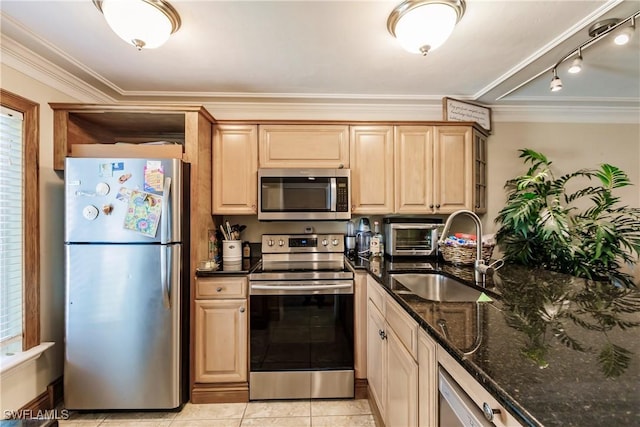 kitchen featuring light tile patterned floors, appliances with stainless steel finishes, a sink, and ornamental molding