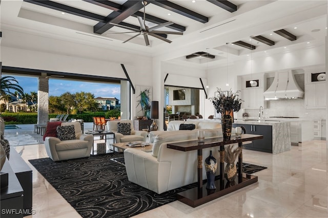 living area with marble finish floor, beam ceiling, a high ceiling, a ceiling fan, and coffered ceiling