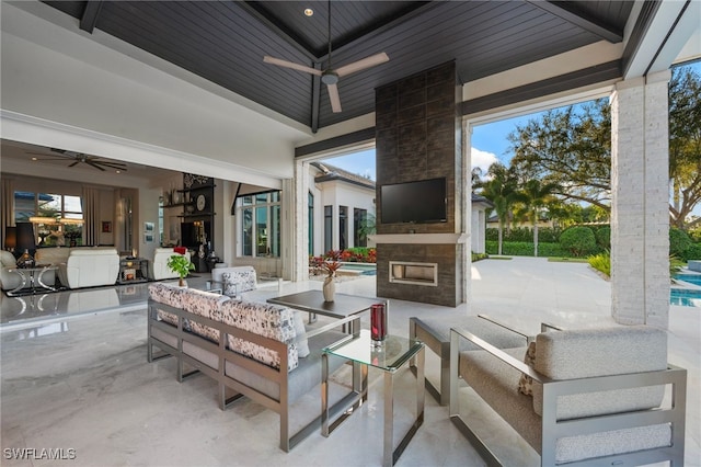 view of patio featuring a ceiling fan, outdoor dining area, and an outdoor living space with a fireplace