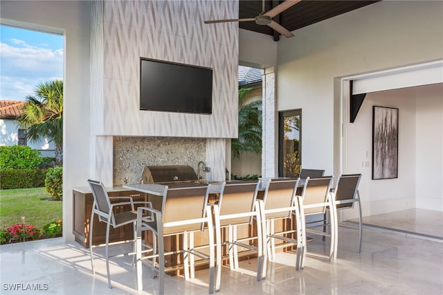 view of patio / terrace featuring ceiling fan, an outdoor kitchen, and outdoor wet bar