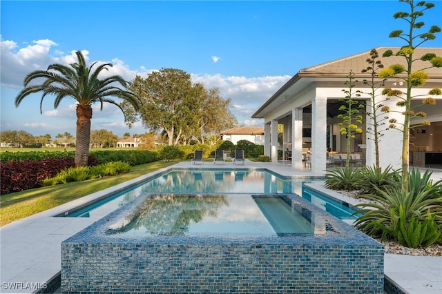 view of pool with a patio area and a pool with connected hot tub