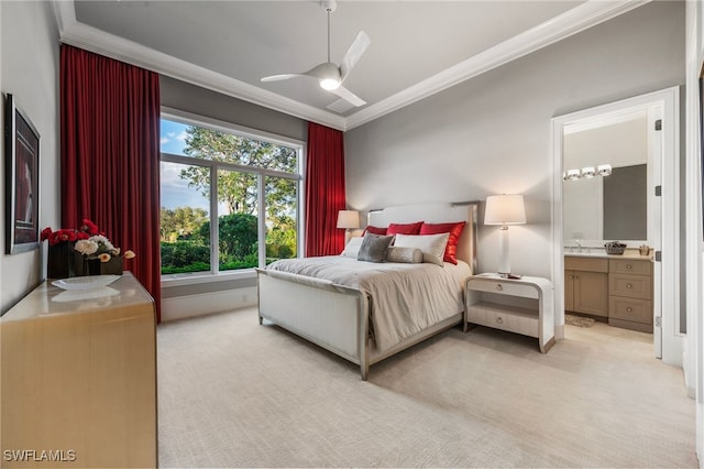 bedroom with ornamental molding, light colored carpet, ensuite bath, and a ceiling fan