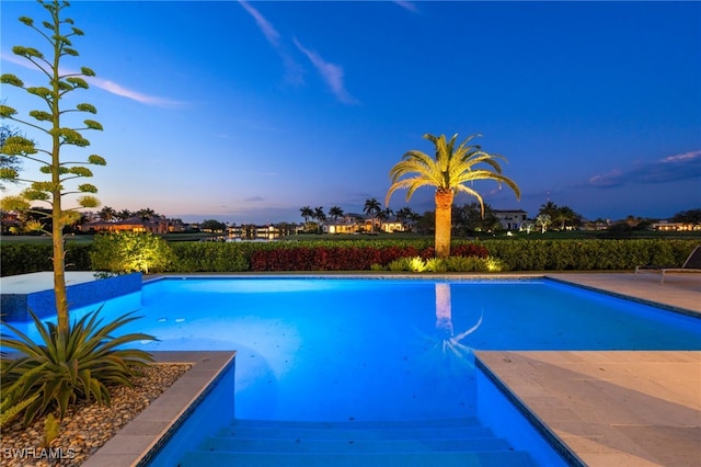 pool at dusk featuring an outdoor pool